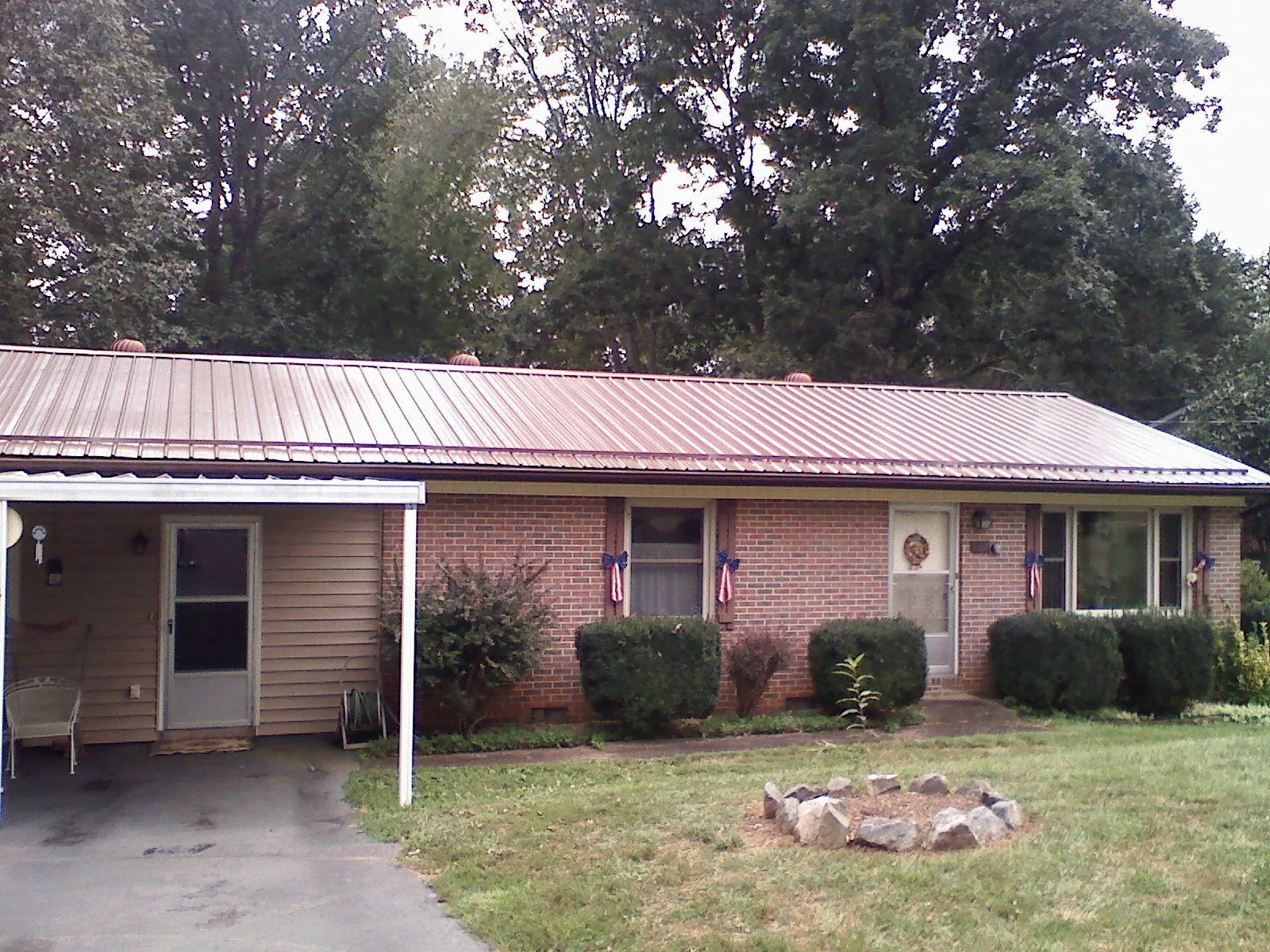 Bronze metal roof and carport on a brick ranch home — Roof Repair work by our crew in Hilton Head Island